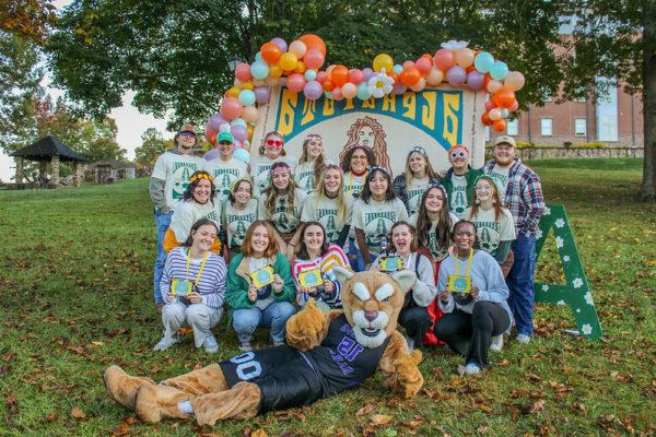 a group of people posing for a photo with a Mountain Lion Mascot